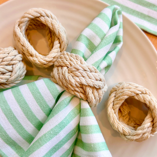 Top Tables natural rope napkin rings. 4 places on cream plate with the Georgia stripe napkin threaded through