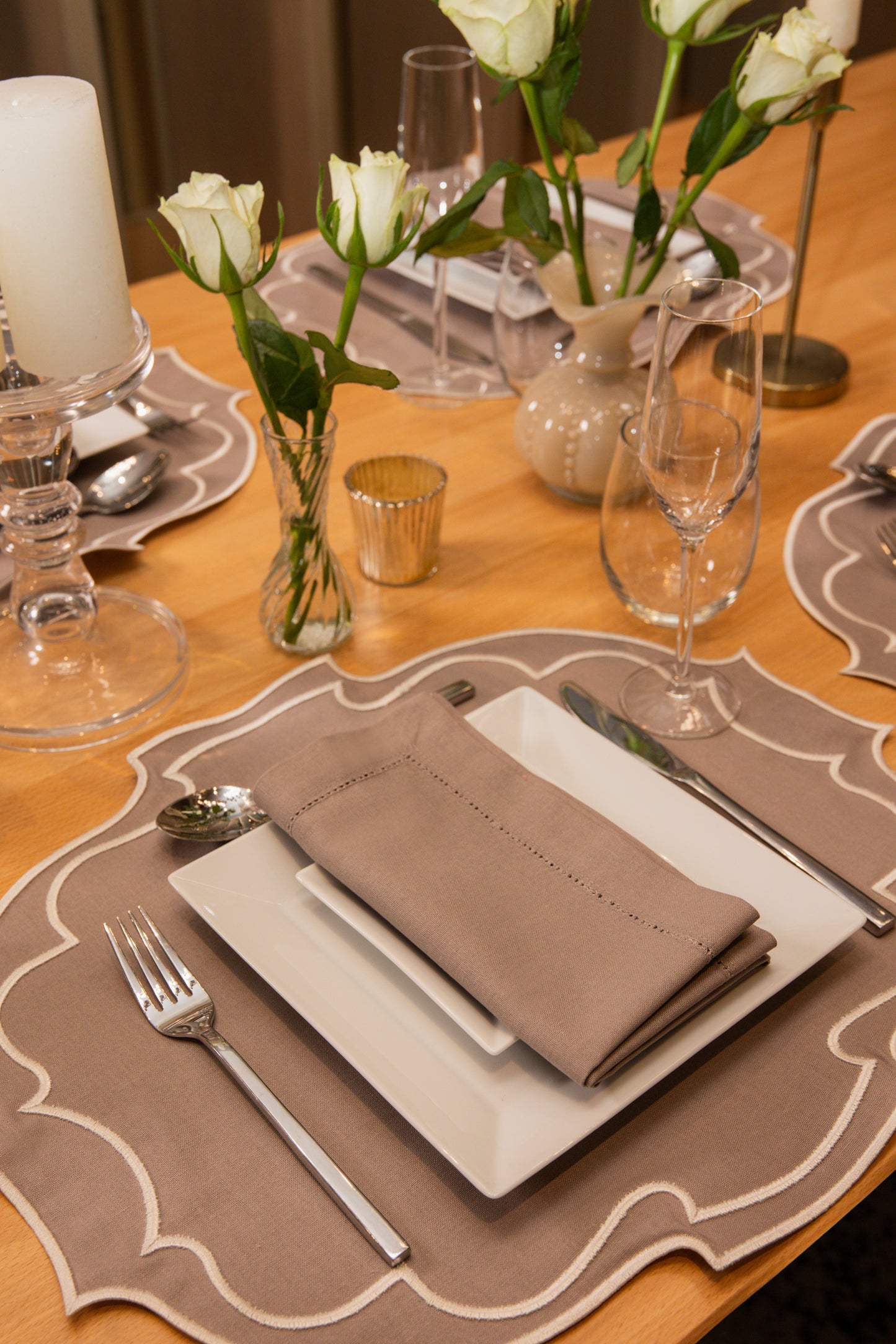 Top Tables Taylor Placemat & Napkin in Latte, featuring scalloped edges and subtle stitching for an elegant table setting.